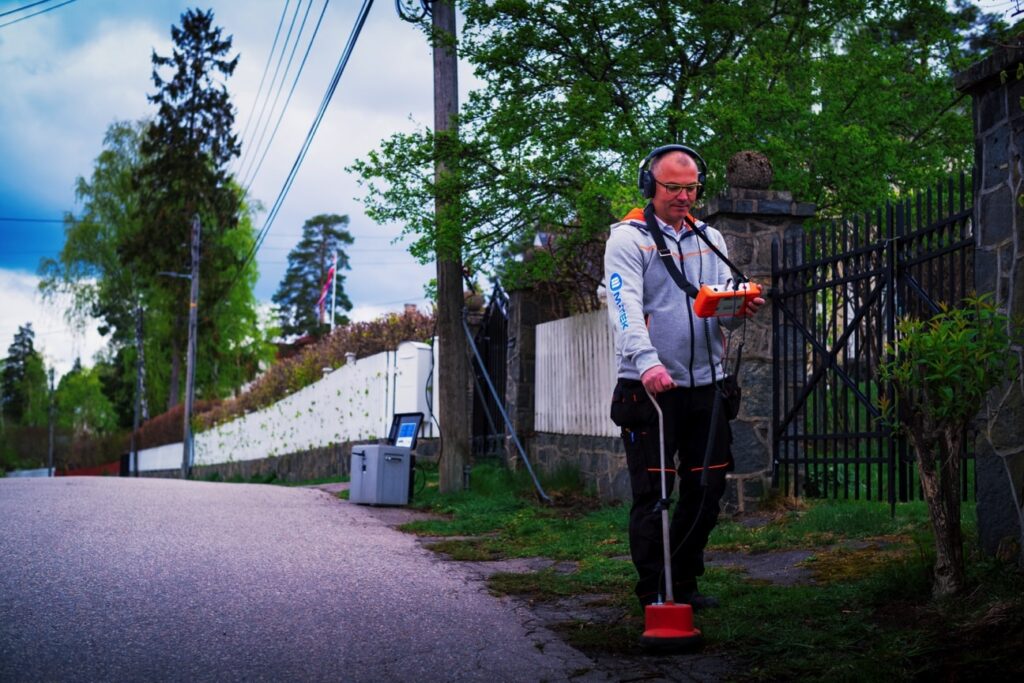Mann som lokaliserer kabler og rør